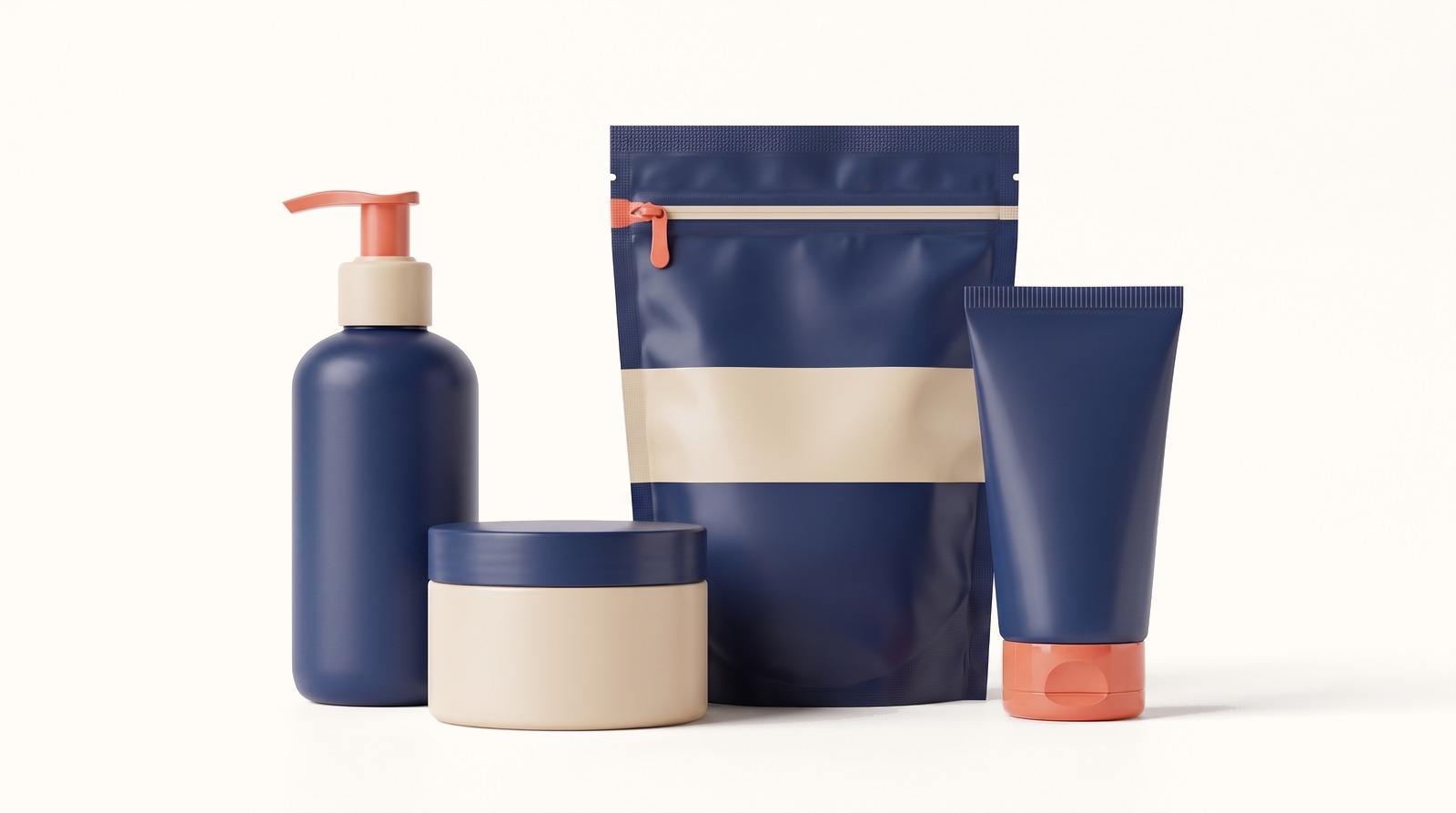 Four pieces of matte skincare packaging from one invented brand, a pump bottle, a jar, a stand-up pouch and a squeeze tube, in deep navy and sand with small coral accents.