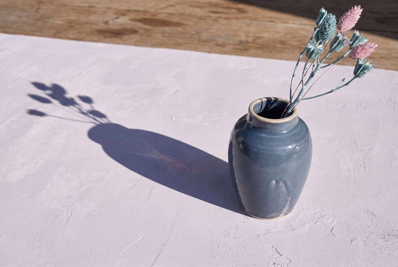 A light summer single-object study: one palette-hex subject (a folded powder-blue knit or a small frosted-glass dish) on cool pale plaster with generous negative space, intentionally quiet after the 24-swatch color block.